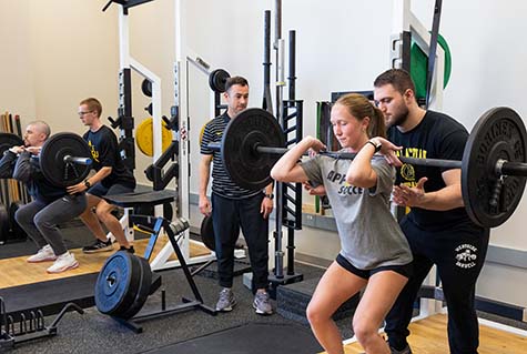 Kinesiology students lifting weights