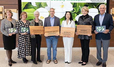 Group shot shows seven folks holding recognition plaques 