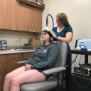 Appalachian alumna Amelia Bruce ’19, standing, prepares a study participant in order to measure the effect of brain stimulation on treating ankle injuries. Photo submitted