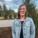 Woman stands outside in front of a tree