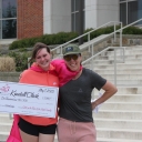 Kendall Clark holds scholarship check with GOTR Board Chair Ashley Galleher