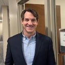 Man stands in the hallway in front of an office