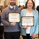 Two individuals holding certificates
