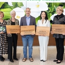 Group shot shows seven folks holding recognition plaques 