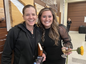 Photo of two females smiling in a building lobby 