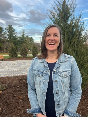 Woman stands outside in front of a tree