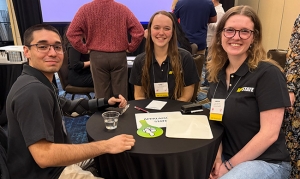 Three students wearing App State shirts sit around a table together