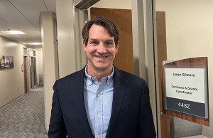 Man stands in the hallway in front of an office 