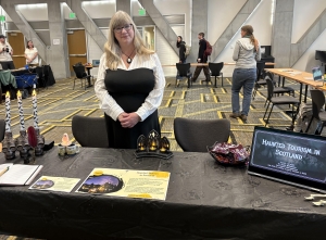Woman stands at a table with a Halloween display
