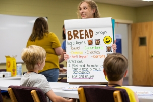App State’s Lauren Sims, a speech-language pathology graduate student from Monroe, center in foreground, provides young students with directions for an activity in App State’s summer 2022 language and reading literacy program. The program, held as part of a summer literacy program offered at the Boone United Methodist Church, pairs healthy snack preparation and sampling with a speech-language pathology curriculum to help children improve their language and literacy skills. Photo by Chase Reynolds