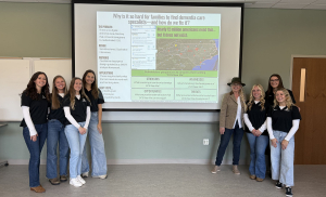 wo groups of women stand clustered around the end of a slide inside a classroom 